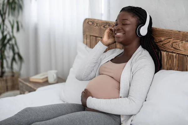 Mutlu Siyah Bekleyen Anne Evde Kablosuz Kulaklıkla Müzik dinlemekten keyif alıyor — Stok fotoğraf