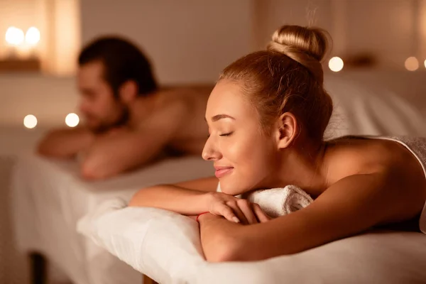 Cônjuges descansando após a terapia de massagem relaxante jazendo no spa — Fotografia de Stock