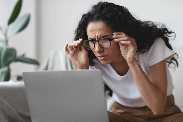 Jonge vrouw met slecht gezichtsvermogen met behulp van laptop, proberen om te werken — Stockfoto