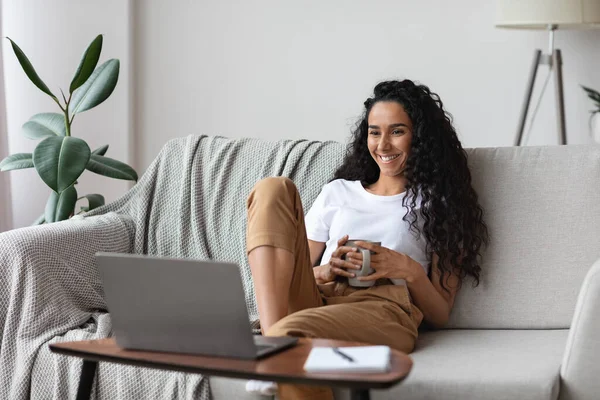 Relaxed young woman watching movie on laptop — Stock Photo, Image