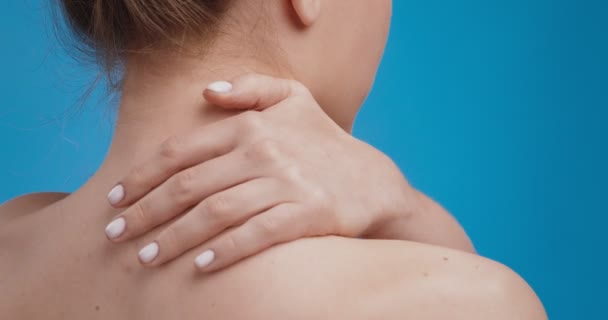 Close-up shot van jonge vrouw masseren haar nek, het aanbrengen van behandeling crème om pijnlijke spieren, achteraanzicht — Stockvideo