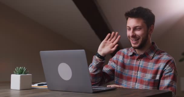 Comunicazione online. Giovane uomo allegro che agita la mano ciao al computer portatile, saluta i colleghi durante la videoconferenza — Video Stock