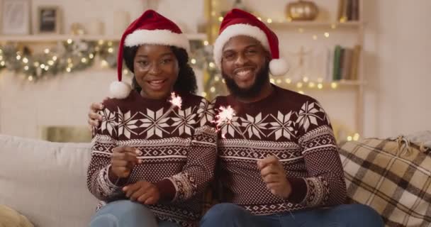 Feliz Navidad y Feliz Año Nuevo. Feliz pareja negra con bengalas divirtiéndose en Navidad en casa — Vídeos de Stock