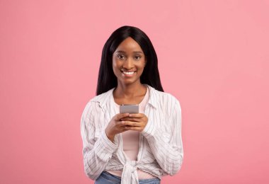 Akıllı telefonda internette gezinen gülümseyen genç siyahi kadın portresi