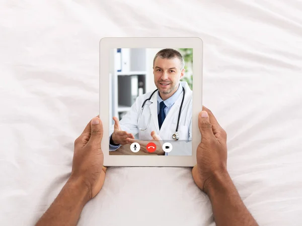 Malato uomo chiamata medico online via tavoletta sdraiato a letto — Foto Stock