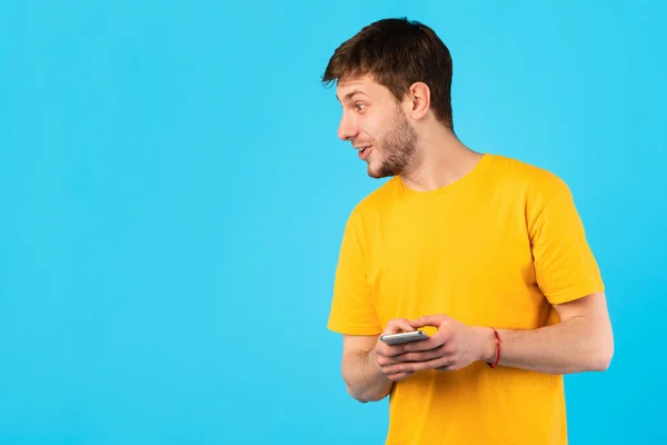 Überraschter Mann benutzt Handy im Studio — Stockfoto