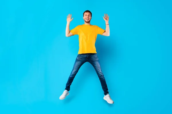 Boldog srác átugrik a kék stúdió falán — Stock Fotó