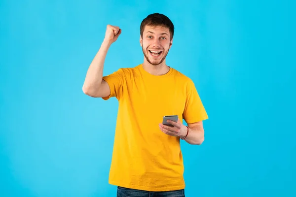 Opgewonden man met behulp van mobiele telefoon, het vieren van online winnen — Stockfoto