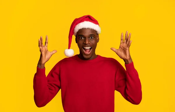 Oferta de Navidad. Shocked negro hombre en santa sombrero levantando manos en excitación — Foto de Stock
