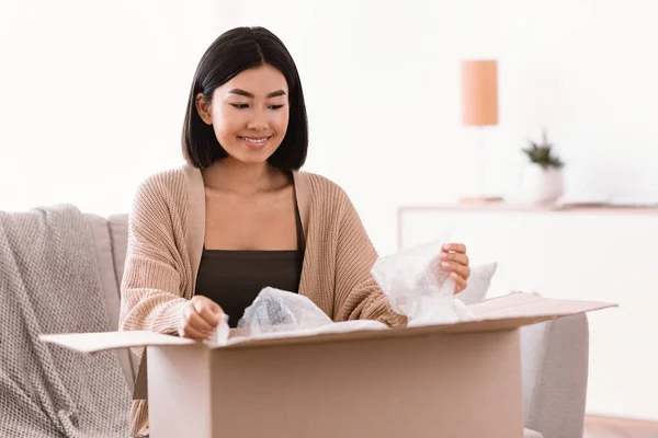 Boldog ázsiai nő kicsomagolás csomag után online vásárlás — Stock Fotó