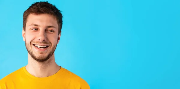 Lächelnder selbstbewusster Mann betrachtet Kopierraum auf blauem Hintergrund — Stockfoto