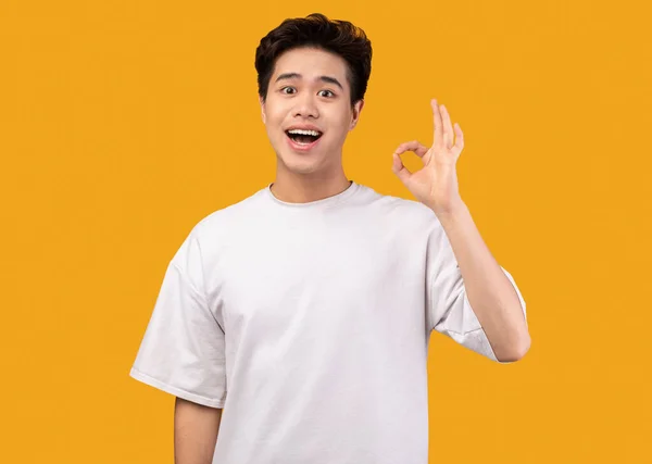 Glücklich asiatisch mann gestikulieren okay und lächelnd — Stockfoto