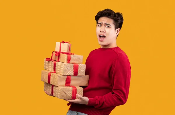 Excited asian guy holding stack of present boxes — Stock Photo, Image