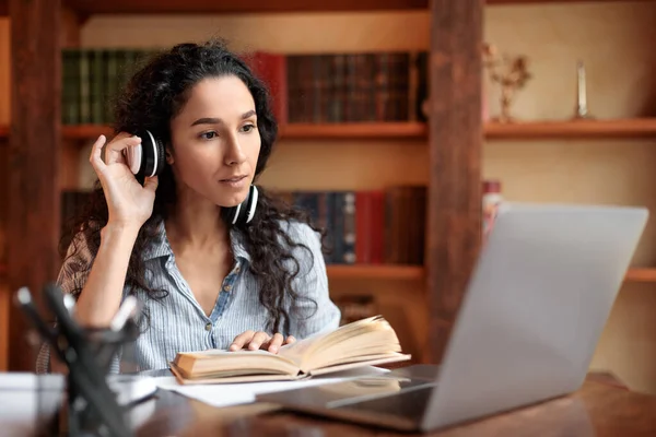 Frau am Schreibtisch, Headset anfassen, Computer benutzen, Buch lesen — Stockfoto
