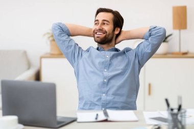 Ofiste dizüstü bilgisayarın başında el ele tutuşan adam.