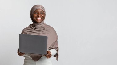 Çevrimiçi kariyer. Rüya Gibi Gülümseyen Siyah Müslüman Kadın Başörtüsü Tutan Laptop Bilgisayarı