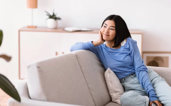 Ázsiai nő miután pihenni otthon a kanapén — Stock Fotó