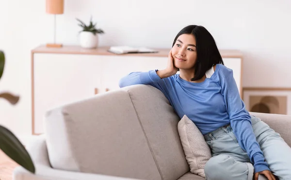 Wanita Asia beristirahat di rumah di sofa — Stok Foto