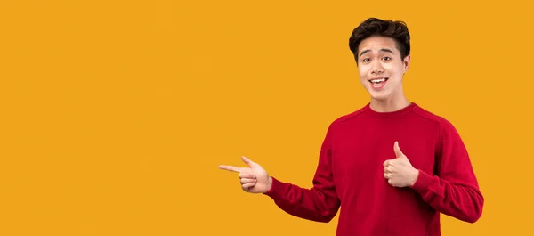 Счастливый азиатский парень указывает пальцем на копировальное пространство, панораму — стоковое фото