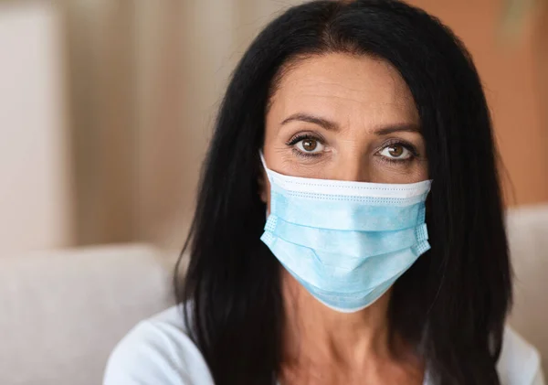 Portret van volwassen vrouw met hygiënisch masker om infectie te voorkomen — Stockfoto