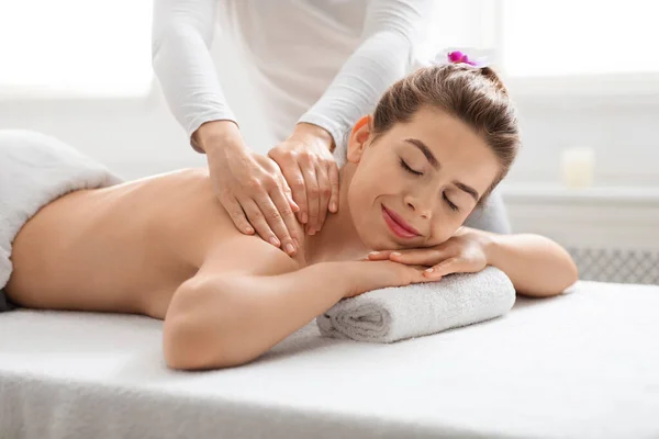 Joyful jovem senhora recebendo de volta massagem no spa — Fotografia de Stock