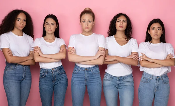 Cinco senhoras multiétnicas descontentes que cruzam as mãos sobre o fundo rosa — Fotografia de Stock