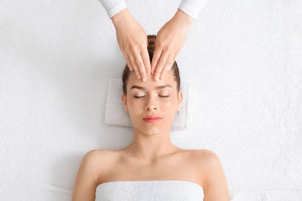 Vista superior de la mujer relajada teniendo masaje facial —  Fotos de Stock