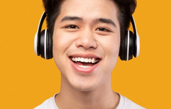 Zdjęcie głowy Portret uśmiechniętego Azjaty w słuchawkach bezprzewodowych — Zdjęcie stockowe