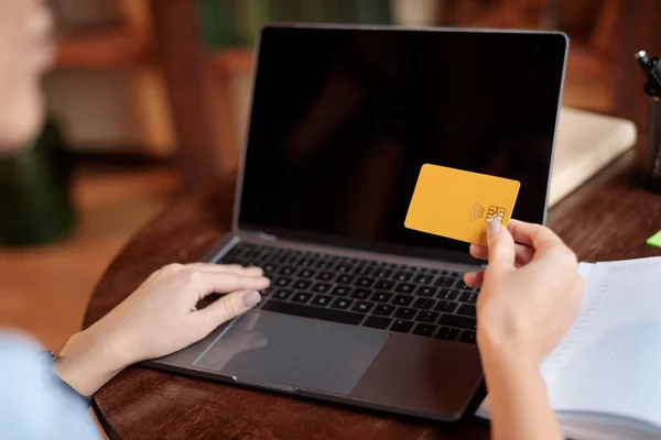 Femme utilisant un ordinateur portable et carte de crédit à la maison — Photo