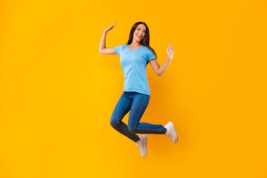 Sarı stüdyo duvarından atlayan mutlu kadın