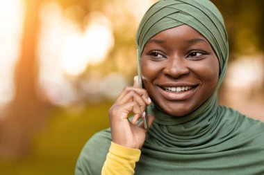 Mobil İletişim. Siyah İslami Kadın Başörtülü Cep telefonuyla dışarıda konuşuyor