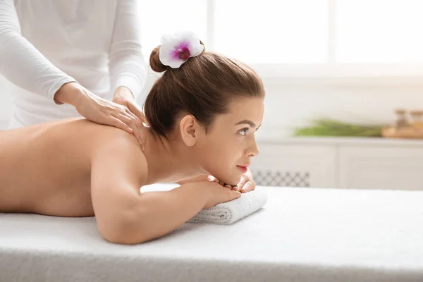 Ładna naga kobieta uczestniczy w salonie spa, dostaje masaż pleców — Zdjęcie stockowe