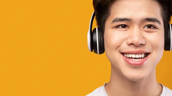 Sonriente asiático hombre disfrutando de la música con auriculares —  Fotos de Stock