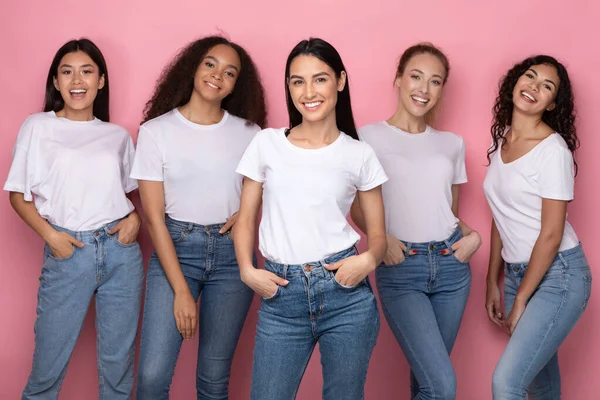 Cinq jolies jeunes femmes mixtes debout sur fond rose — Photo