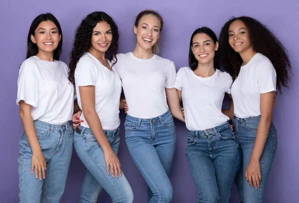 Cinco alegres senhoras diversas posando abraçando e sorrindo, fundo roxo — Fotografia de Stock