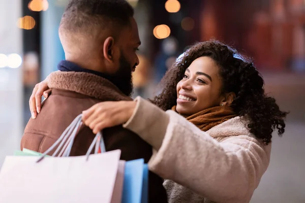 Happy black couple hugging and holding shopping bags — Stock Photo, Image