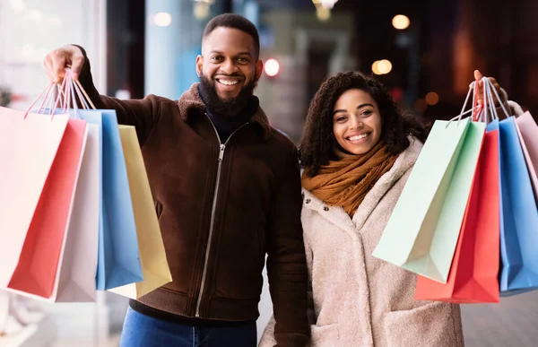 Retrato de feliz pareja negra con bolsas de compras —  Fotos de Stock