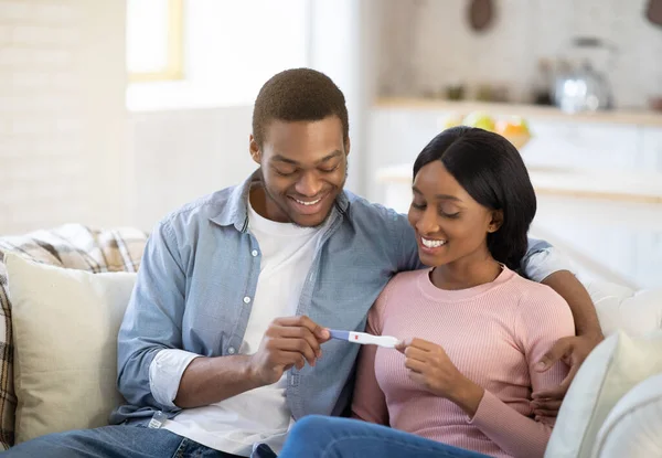 Paternidad y maternidad. Futuros padres negros con prueba de embarazo positiva esperando un bebé, emocionados por una nueva vida — Foto de Stock