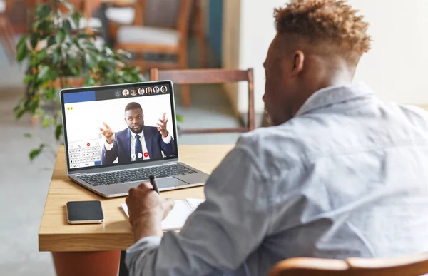 Guy attending online training with business coach, listening, taking notes — Stock Photo, Image