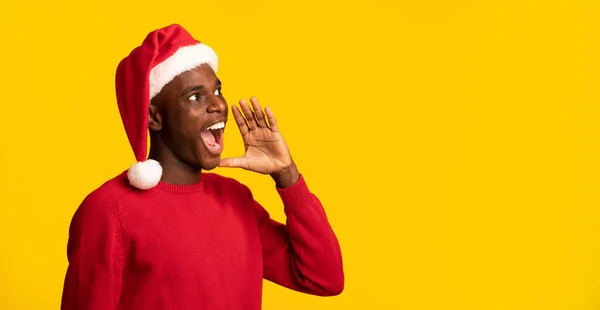 Negro chico en santa sombrero gritando en copia espacio, haciendo navidad anuncio — Foto de Stock