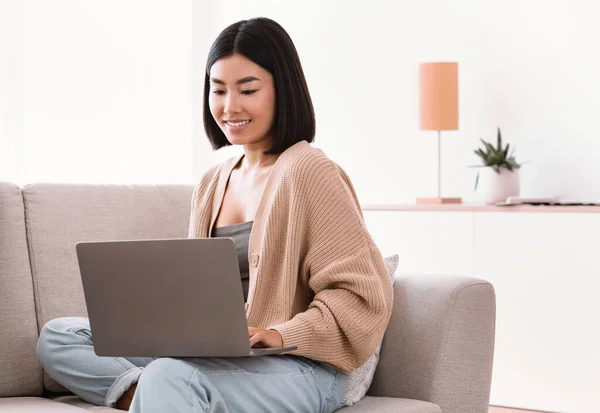 Asiatico donna seduta su divano e lavoro su computer — Foto Stock