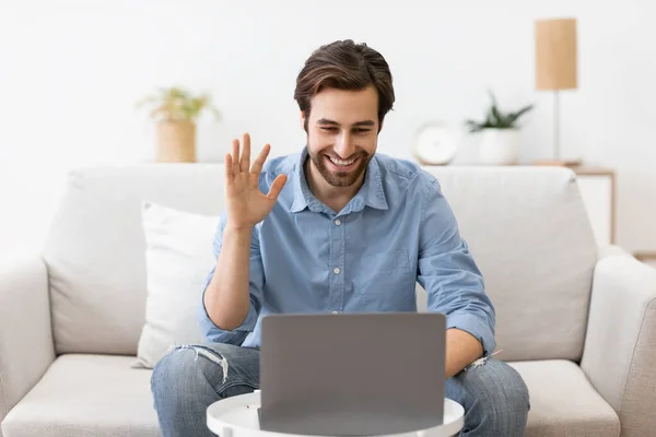 Homem acenando para laptop fazendo chamada de vídeo sentado em casa — Fotografia de Stock