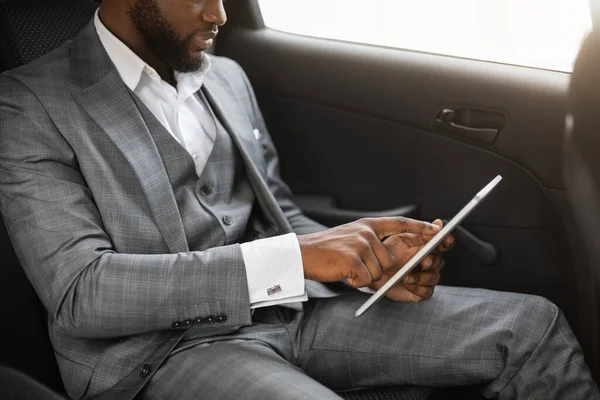 Afrikanischer Geschäftsmann mit digitalem Tablet im Auto nicht wiederzuerkennen — Stockfoto