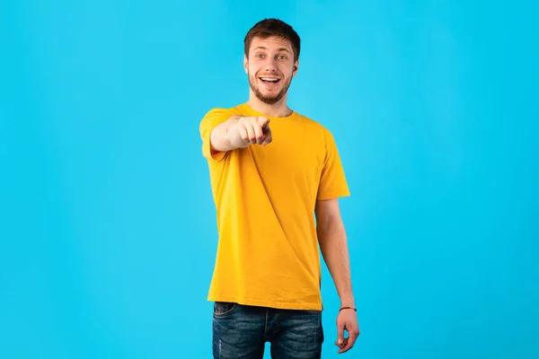 Щасливий хлопець вказує палець на камеру в студії — стокове фото