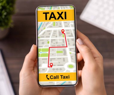 Taksi uygulaması arayüzü olan akıllı telefonu tutan genç bir kadın.
