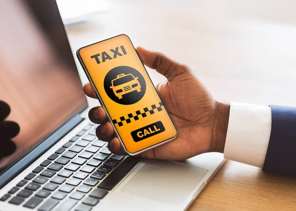 Homme noir tenant téléphone portable avec interface d'application de taxi — Photo