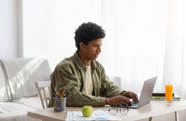 Alegre preto teen cara ter vídeo conferência no laptop com professor de casa — Fotografia de Stock