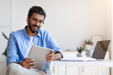 Evde dijital tablet kullanan serbest çalışan Hintli adam işe ara verdi.