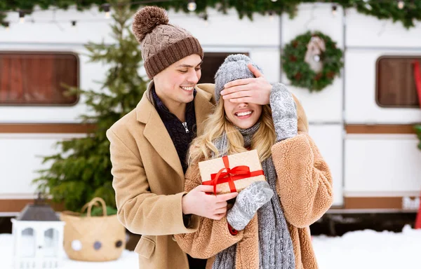 Weihnachtsüberraschung. Loving Young Guy Covering Girlfriends Eyes Outdoors Und Giving Geschenk — Stockfoto