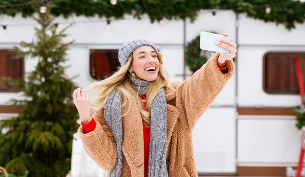 Selfie exterior. Mujer rubia alegre tomando fotos con Smartphone en el campamento de invierno —  Fotos de Stock